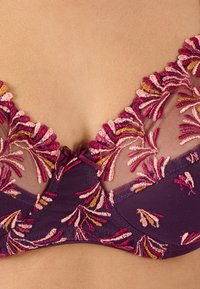 Reggiseno viola in morbida rete con intricato ricamo floreale rosa e arancione. Completato con un piccolo dettaglio a forma di fiocco centrale.