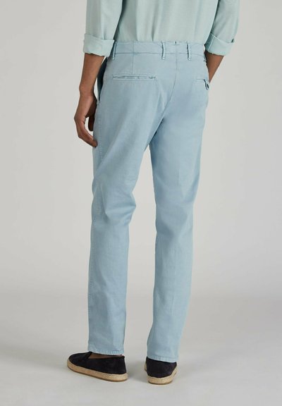 Chinos azzurri chiari con un design a gamba dritta, dotati di tasche posteriori e una superficie liscia. Abbinati a espadrillas scure.
