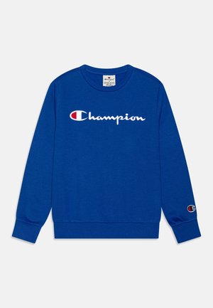 Niebieska bluza Champion z długim rękawem, z białym i czerwonym logo tekstowym na środku klatki piersiowej oraz małą naszywką z logo na mankiecie lewego rękawa.