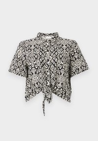 Crop top à manches courtes noir et blanc avec un motif en diamant et un détail de nœud à l'avant. Fabriqué en tissu léger avec un col.