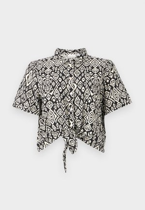 Black and white short-sleeve crop top with a diamond pattern and a front tie detail. Made of lightweight fabric with a collared neckline.