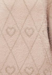 Zacht roze fuzzy stof met metallic gouden diamantpatronen, waarin elke diamant een hartvorm bevat binnen het ruitpatroon.
