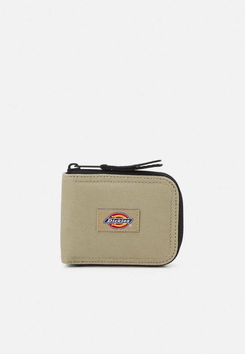 Billetera con cremallera en lona beige con detalles en negro. Presenta un parche con el logo, una superficie texturizada y un diseño práctico.