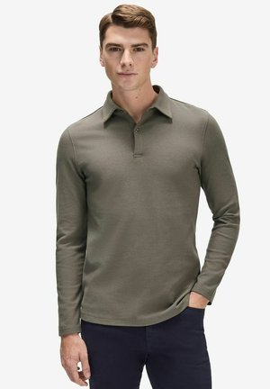 Långärmad, olivgrön polo skjorta med krage, knappslå och en mjuk textur. Matchas med mörka byxor, minimalistisk design.