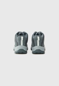 Scarpe sportive grigie con una parte superiore testurizzata, tallone rinforzato e una linguetta bianca. La suola presenta un motivo di battistrada robusto per una migliore aderenza.