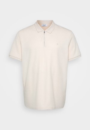 Beige short-sleeve polo shirt with a collar, front zip, and subtle textured fabric. Small logo on the left chest.