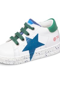 Sneaker bianca con design a stella blu, accenti verdi e lacci verdi. La suola in gomma presenta un motivo spruzzato. Dettaglio del logo in rosso.