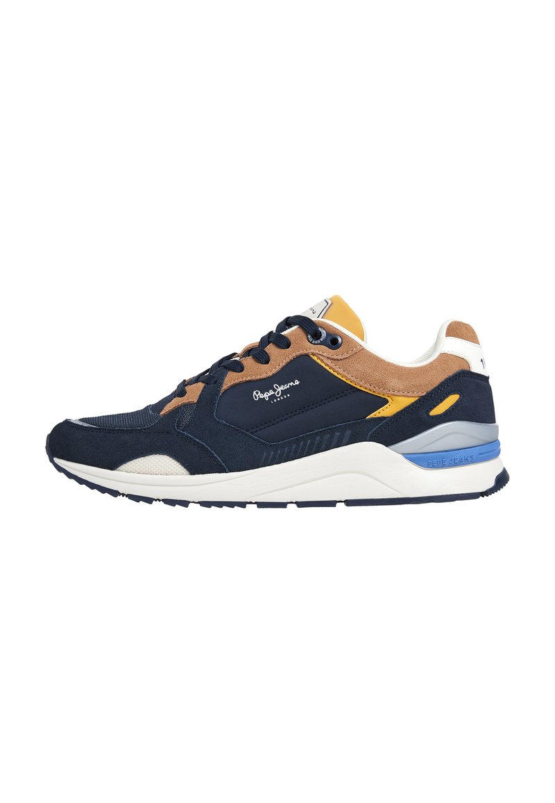 Sneaker blu, beige e marrone realizzata con una combinazione di materiali tra cui suede e mesh. Presenta una spessa suola bianca e dettagli gialli.
