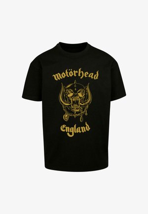 Tricou din bumbac negru cu un design grafic auriu reprezentând un craniu cu coarne și textul "motörhead" și "Anglia" în partea de jos.