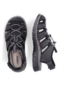 Sandales noires à design ouvert, en matériau synthétique texturé, avec des brides réglables et une semelle intérieure rembourrée pour un confort optimal.