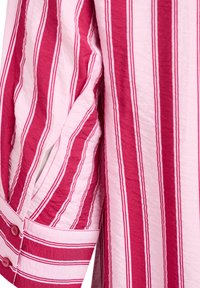 Striped shirt in pink and red hues with a textured fabric. Features buttoned cuff and contrasting vertical stripes of varying widths.