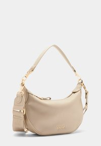 Borsa a tracolla in pelle beige con hardware dorato, forma arrotondata, superficie texturizzata e tracolla regolabile con un accento decorato. Logo del marchio visibile.