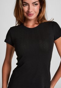 Zwarte, slim fit, korte mouwen t-shirt met ribbelstructuur en subtiele verticale patronen, ronde halslijn, gemaakt van zacht materiaal.