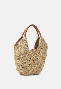 Handgeweven beige draagtas met een ingewikkeld textuurpatroon en bruine leren handvaten op een witte achtergrond.