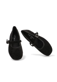 Zapatos Mary Jane de ante negro con puntera redonda y una correa con un acento de hebilla plateada. Textura suave y diseño de suela plana.