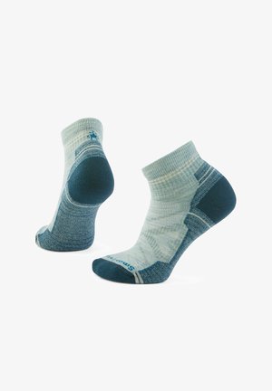 Knöchelhigh Socken in hellem Teal und dunklem Teal, mit einem strukturierten Muster, verstärktem Fersen- und Zehenbereich sowie kontrastierenden Akzenten.