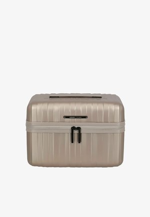 Estuche de viaje compacto de color beige con carcasa dura, bandas horizontales, cierre de cremallera doble y asa superior.