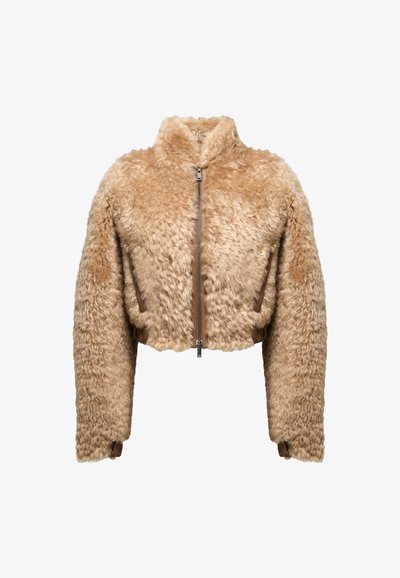 Izgriezts žakets, izgatavots no pūkaina bēša auduma ar augstu apkakli, priekšējo rāvējslēdzēju un brūniem akcentiem viduklī un piedurknēs.