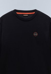 Sudadera negra con cuello redondo, interior naranja, y un pequeño logo circular con acentos rojos y negros en el pecho.