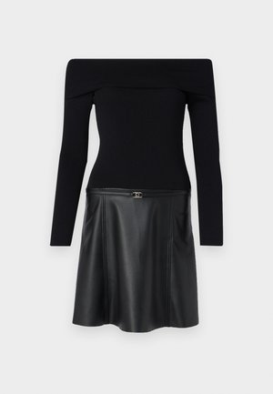 Top nero senza spalle con maniche lunghe, abbinato a una gonna nera in ecopelle con chiusura con cerniera e leggero svaso all'orlo.