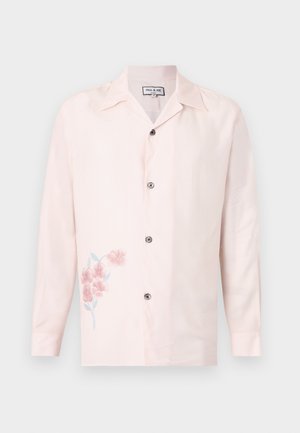 Lyserød skjorte med lange ærmer, knapper og en skåret krave med et lille lyserødt blomsterprint på nederste venstre side.