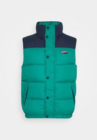 Chaleco acolchado con cuerpo verde y hombros azul marino, con cuello redondo, botones a presión y dos bolsillos laterales.