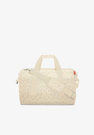 Beige duffel bag with subtle leopard print, dual carry handles, adjustable shoulder strap, and zippered main compartment.
