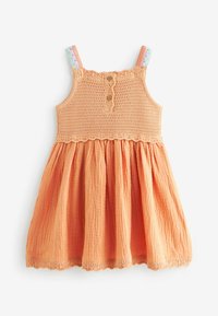 Abito per bambini in cotone arancione, intrecciato, con busto arricciato, tre bottoni in legno e spalline decorate. Gonna fluente con dettaglio a bordo scallop.