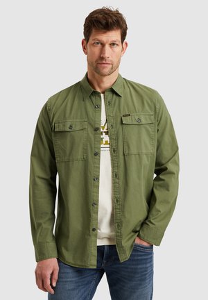 Grüne Button-Down-Hemd mit zwei Brusttaschen, aus Baumwolle, mit klassischem Kragen und durchgehender Knopfleiste, übereinander getragen mit einem hellen Hemd.