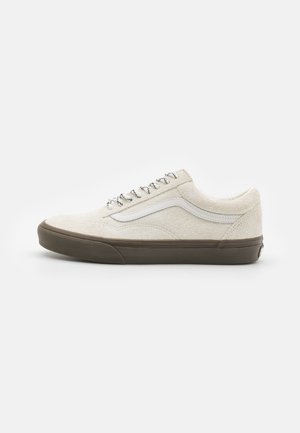 White textured sneakers with gray accents, featuring a rounded toe, flat laces, and rubber soles. Iconic side stripe in white.