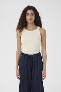 Mouwloze crèmekleurige geribbelde tanktop, gecombineerd met loszittende marineblauwe broek met elastische tailleband en trekkoord detail.