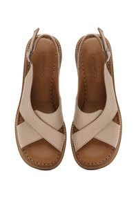 Sandali slingback beige in pelle con cinturini incrociati, dettagli testurizzati sulla suola e una soletta confortevole. Finitura in tonalità chiara.