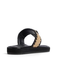 Black platform sandal with woven natural fiber accents, rounded strap, and textured footbed. Decorative stitching along strap edges.