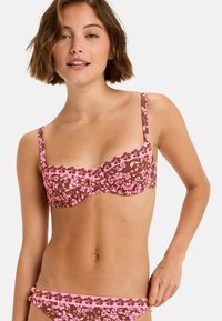 Brun bikini top med pink blomstermønster, underwire støtte og justerbare stropper; matchende bikiniunderdele med pink kant og gyldne hardwaredetaljer.