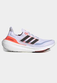 Chaussure de running Adidas Ultraboost blanche avec des bandes noires, un accent orange au talon et une semelle épaisse et rembourrée vue de côté.
