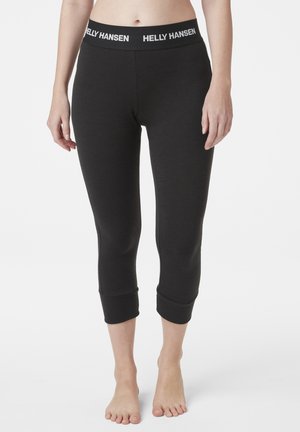 Leggings capri negros con una amplia cinturilla elástica con la marca "HELLY HANSEN". El material parece suave y ajustado, con un dobladillo acampanado.