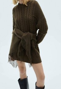 Robe pull en vert olive foncé avec des motifs en relief, des bords côtelés et une ceinture à franges, finie avec des épaules tombantes et des manches longues.