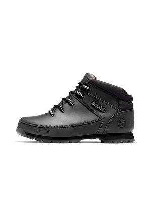 Sort vandrestøvle i mellem højde med polstret krave, metaløjer, robust sål og Timberland-logo på hæl og sideside.