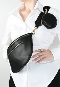 Borsa a tracolla nera in pelle con superficie testurizzata, zip dorate e un portamonete rotondo attaccato. Presenta una tracolla con motivo e più scomparti.