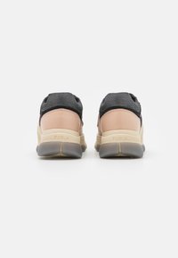 Furla sneakers with a black knit upper and smooth beige leather accents. Features a rubber sole with a subtle gray tint and logo detailing.