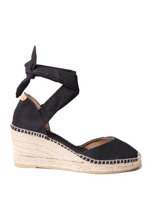 Zwarte canvas wedge espadrille met een geknoopte enkelband, jute-omhulde platte zool en een open teenontwerp.
