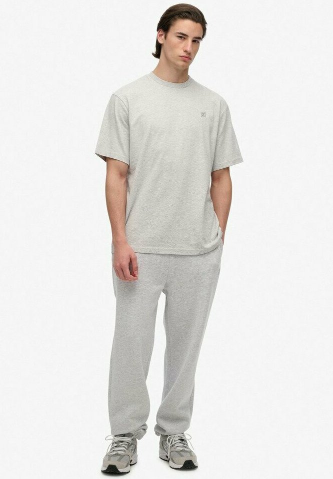 Lysegrå bomulds t-shirt med rund hals, parret med matchende tapered sweatpants. Sneakers har grå og sorte accenter.