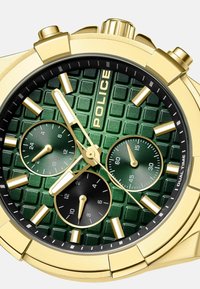 Zelta tonis chronograph pulkstenis ar zaļu teksturētu ciparnīcu, trim mazākiem melniem subciparnīcām un zelta stundu rādītājiem. Iespējas ietver melnu rāmīti.