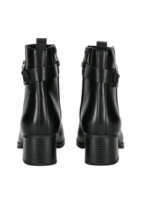Botas de tobillo de cuero negro con tacón cuadrado, cremalleras laterales y correas ajustables con hebillas metálicas. Textura suave, con un diseño minimalista.