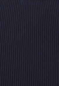 Marinblå ribbad trikå med vertikala ränder, med en mjuk textur och konsekvent mönster genom hela tyget. Lämpligt för kläddesign.