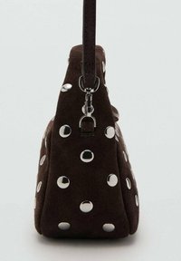 Bolso de mano de ante marrón con forma triangular, adornado con tachuelas circulares plateadas, con una única correa y un cierre metálico.