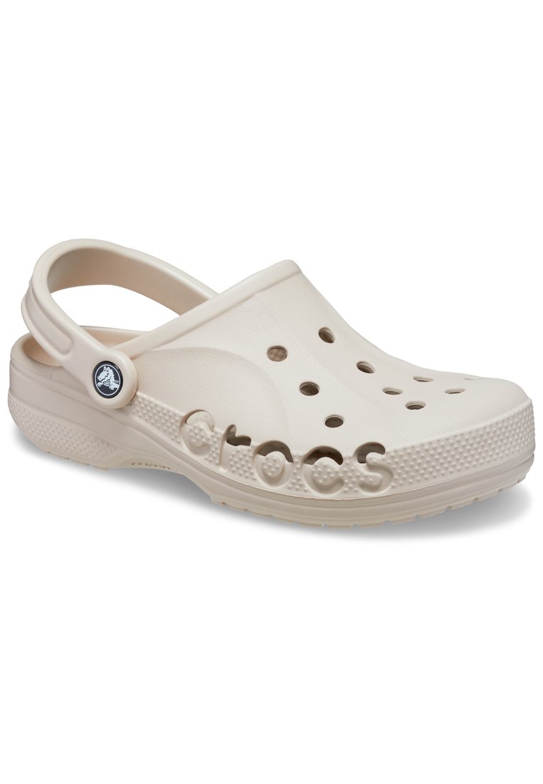 Beige Crocs met een lichtgewicht, gevormd ontwerp, voorzien van ventilatiegaten, een achterste band en een verhoogd logo aan de zijkant. Textuurzool.