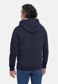Sudadera azul marino con capucha ajustable, puños y bajo acanalados, hecha de un tejido suave. Presenta un diseño sencillo sin logotipos visibles.