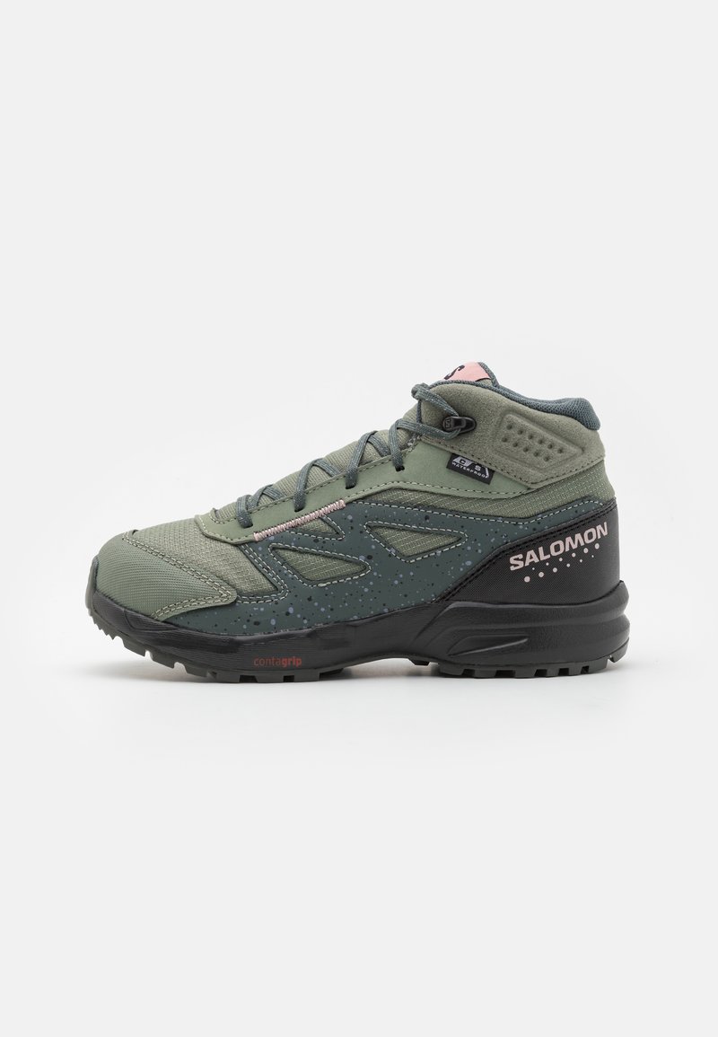 Zapatilla de senderismo verde de media caña con un upper texturizado, suela de goma negra, acentos rosas y puntera reforzada para mayor durabilidad.