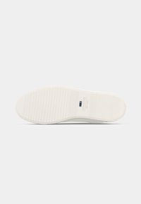 Shoe sole with horizontal grooves, light color, branding reading "JACK & JONES EST. 1990" near the heel area.